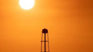 Water tower silhouetted against a hazy summer sky, illustrating the St. Tammany Parish heat advisory