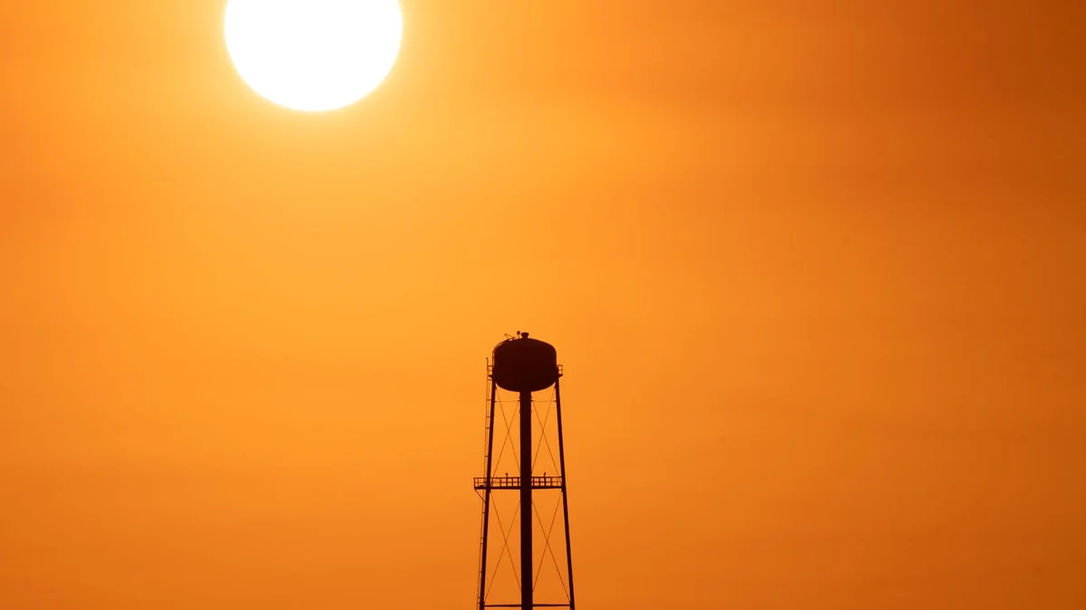 Water tower silhouetted against a hazy summer sky, illustrating the St. Tammany Parish heat advisory