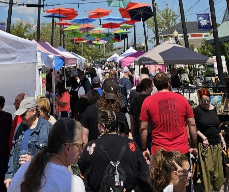 Shoppers crowd First Street between vendor tents under a canopy of colorful umbrellas at the Olde Towne Slidell street fair.