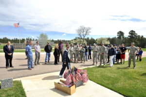 Volunteers placing American flags at veterans grave markers in a military cemetery, file photo