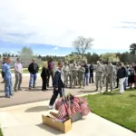 Volunteers placing American flags at veterans grave markers in a military cemetery, file photo